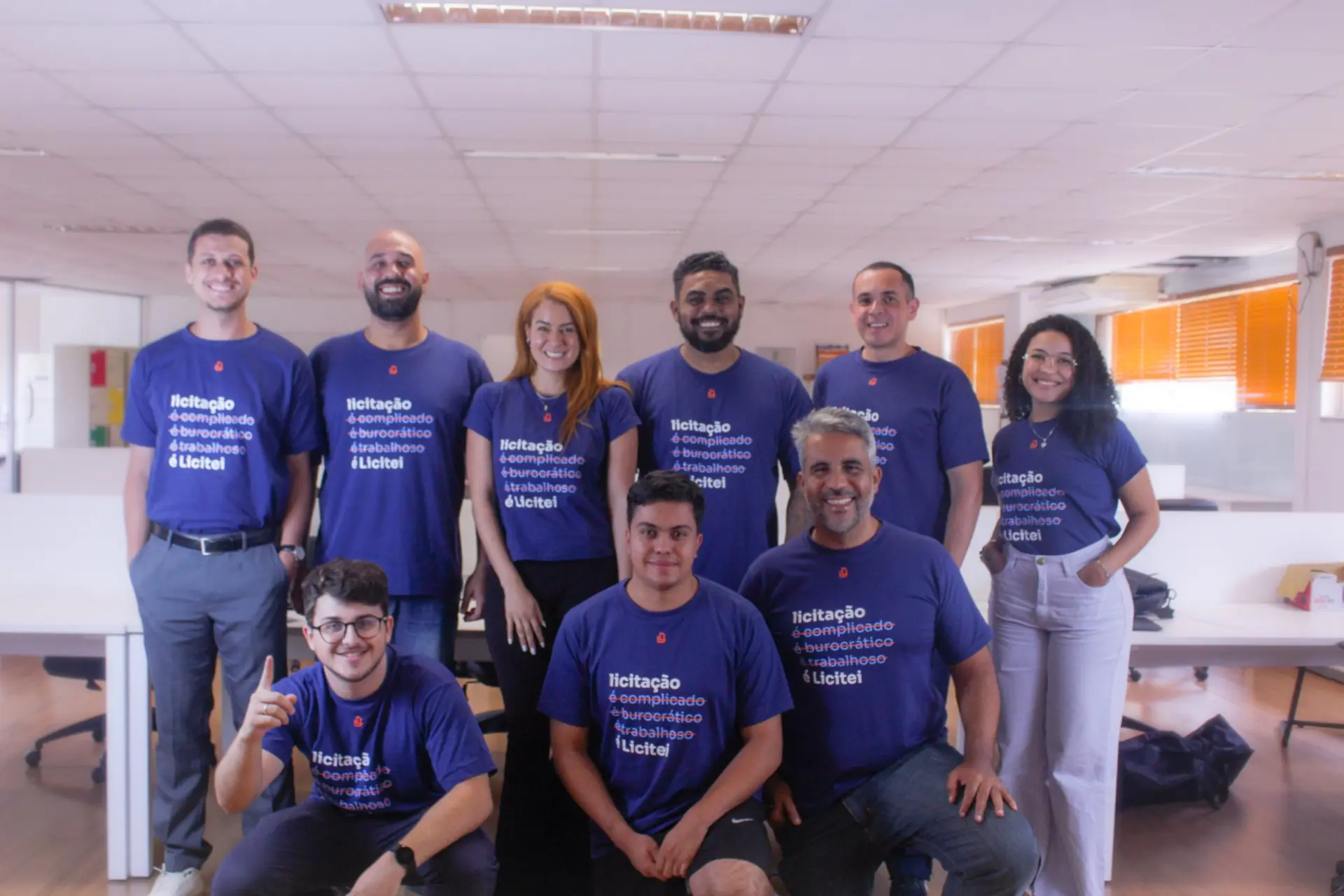 Time da Licitei reunido no escritório, com camisetas azuis da startup